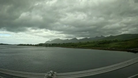 Wide view crossing bridge past fjord and sharp mountain peaks in Senja Norway Vidéo 342340385