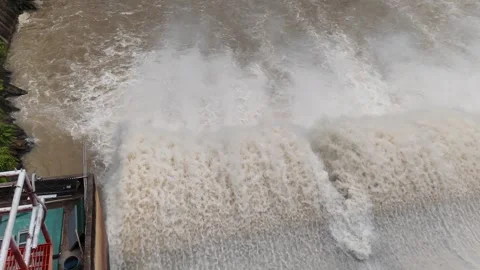 Wide view of dam water release, strong brown floodwater with heavy splash. Stock Footage 315569073