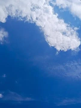 Wide view of a deep blue sky with large white cloud formations creating a clean 库存照片
