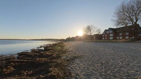 Wide view of Eckernfoerde beach at sunset with calm Baltic Sea shoreline and Video stock 328993061