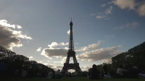 Wide view of the Eiffel Tower from the Champ de Mars park during a spring sunset Stock Footage 321929964