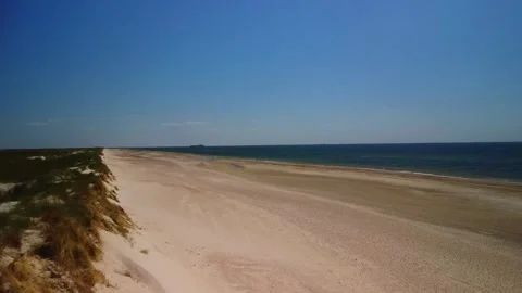 Wide view of empty beach and blue water on sunny day with clear sky and dis.. Stock Footage 339937177