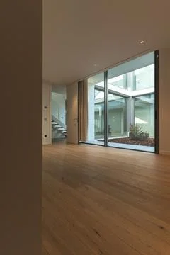 Wide view of an empty interior room with parquet floor and view of the inner Foto stock