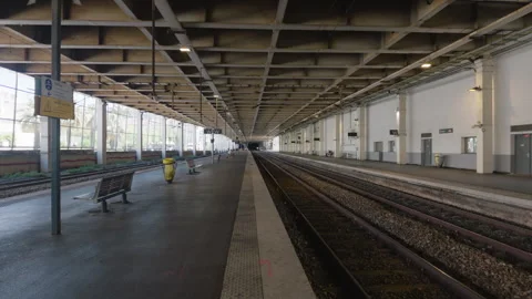 Wide view of an empty train station platform with benches and tracks, Cannes, Vídeos de archivo 344825366