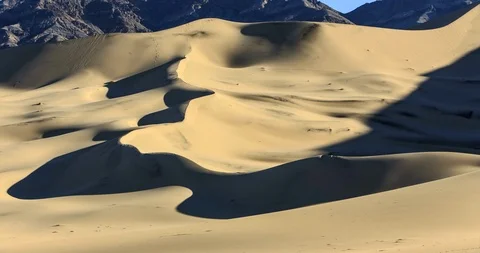 Wide view of Eureka Dunes with mountains in the background Stock Footage 89421519