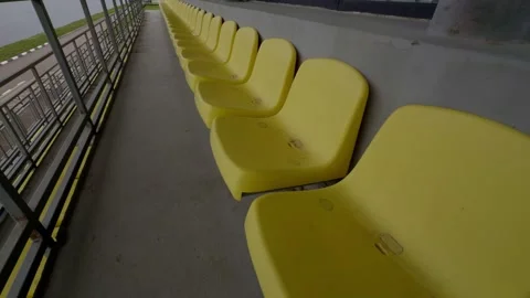 A wide view featuring a series of Empty Yellow Stadium Seats positioned Stock Footage 313286732