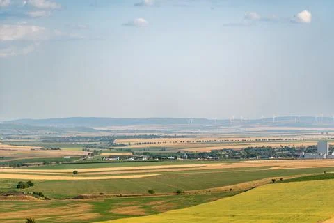 Wide view of fields, wind turbines, and distant hills on a sunny day in a r.. Stock Photos