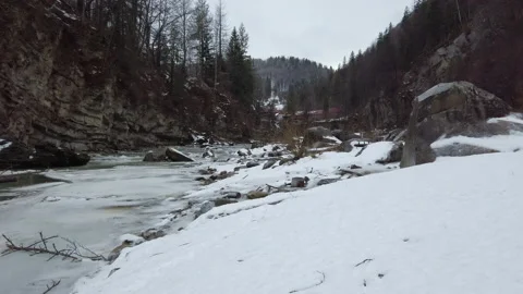 Wide view of frozen river stream at rocky terrain at mountains. Traveling at nat Video stock 148448546