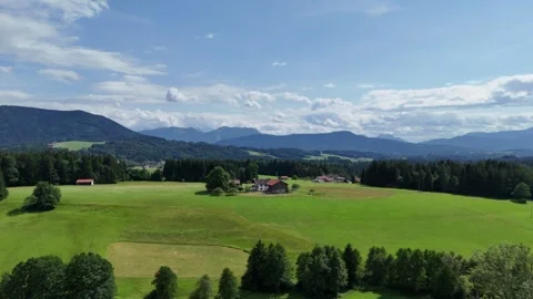 Wide view of green pastures, forests and traditional village houses Vidéo 338350323
