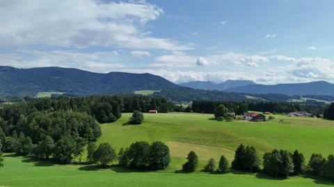 Wide view of green pastures, forests and traditional village houses Vídeo Stock 338350325