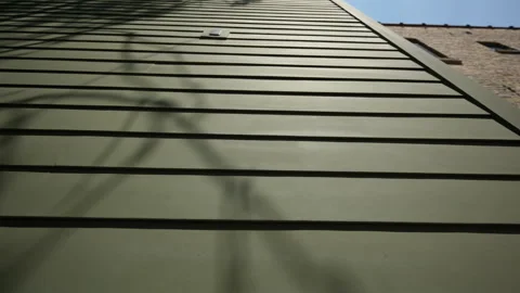 Wide view of green siding of the house wall with modern panels, providing a Stock Footage 317063448
