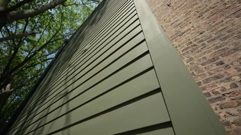 Wide view of green siding of the house wall with modern panels, providing Stock Footage 317208532