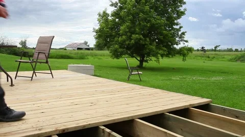 Wide view of guy screwing deck together Stock Footage 51731588