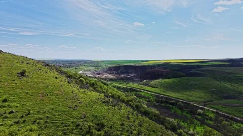 Wide view of hills and fields near a mining site in daytime Stock Footage 338241358