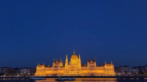 Wide view of Iconic Országház at nighttime, Boats sailing on Danube River Stock Footage 334812137