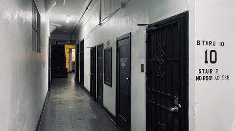 Wide view of interior hallway with white walls and black doors Stock Photos