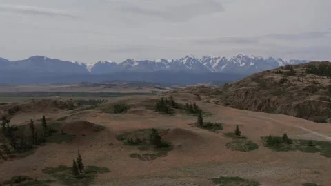 Wide view of Kurai Steppe valley and snowcapped Altai Mountains, Russia Stock Footage 334100784