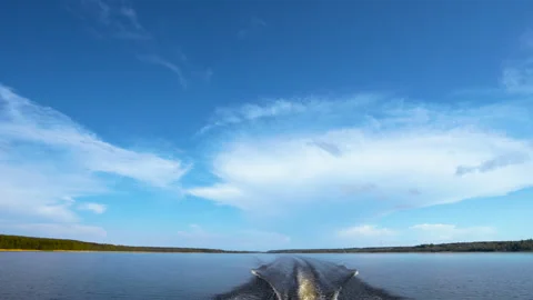 Wide view of a lake and forest horizon with boat wake on water Stock Footage 310190955