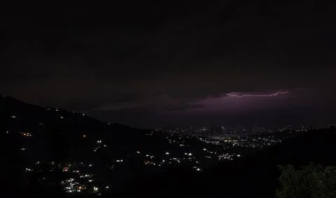 Wide view of a lightning storm over a mountain town in Himachal Pradesh. Stock Photos