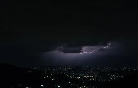 Wide view of a lightning storm over a mountain town in Himachal Pradesh. Stock Photos
