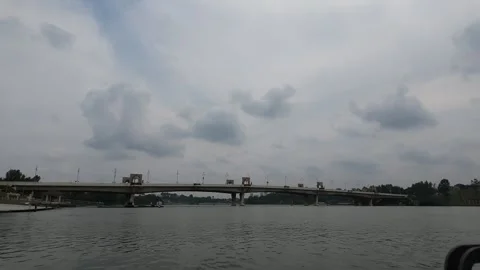 Wide view of a long bridge spanning across Putrajaya Lake under a overcast sky. Stock Footage 340873275
