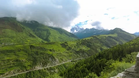 Wide View of Lush Green Mountain Valley and Snow Capped Peaks in Summer 動画素材 342014356