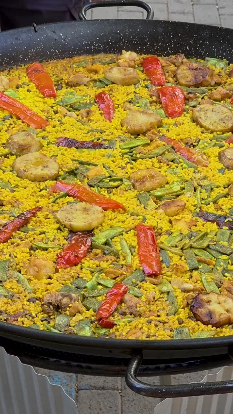 Wide view of a massive traditional Spanish paella pan filled with yellow saf Vídeo Stock 345172553