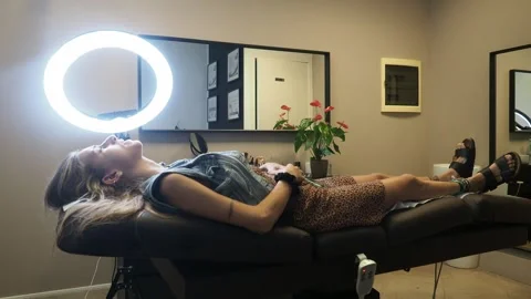 Wide view of microblading session with client relaxed and artist working under Stock Footage 307573145