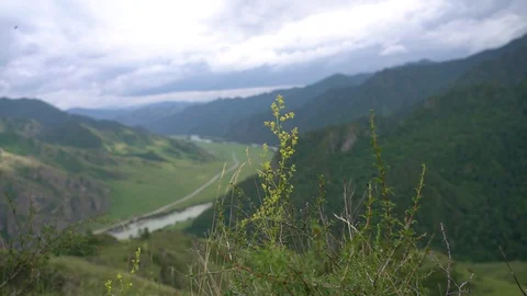 Wide view of mountain valley with river and road Stock Footage 129660608