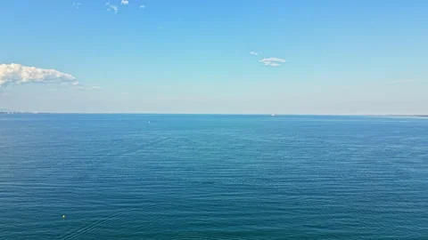 Wide view of the ocean under a clear sky with a few clouds and horizon visible Stock Footage 340931528