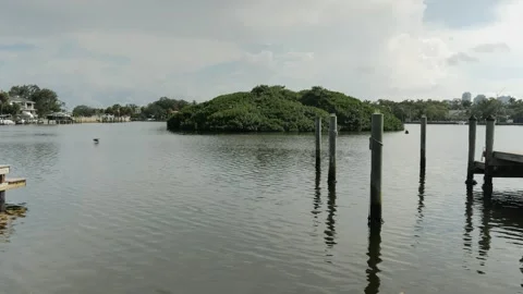 Wide view over water to Coffee Pot Bayou bird preserve a small island packed wit Stock Footage 284734152