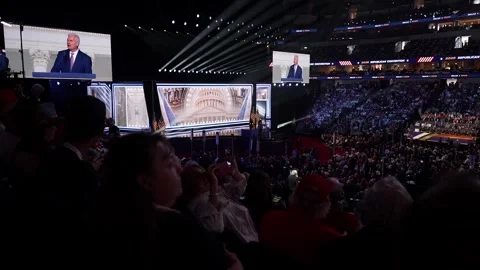 Wide view of the packed arena as a speaker appears on the giant screens Stock Footage 345272152
