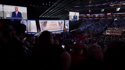 Wide view of the packed arena as a speaker appears on the giant screens Stock Footage 345272153