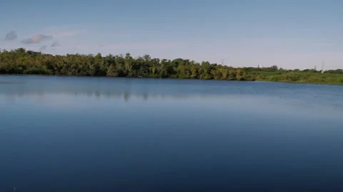 Wide view pan left to right of Sawgrass Lake Park over the surface of the blue w Stock Footage 283298005