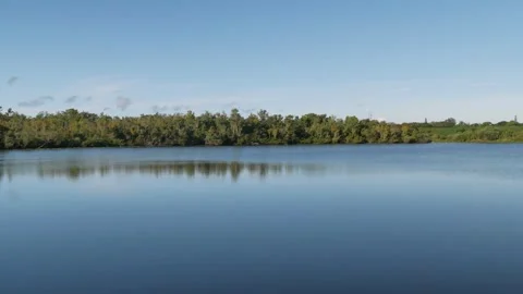 Wide view pan left to right of Sawgrass Lake Park over the surface of the blue w Stock Footage 283298162