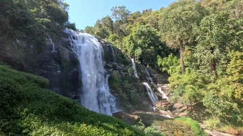 Wide view of powerful multi-tiered waterfall cascading over rocks in northern Stock Footage 339921521