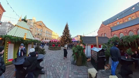 Wide view of Riga Old Town holiday market with a decorated tree, wooden stalls Stock Footage 327322924