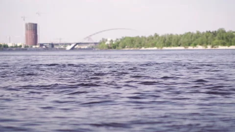 Wide view of the river and the bridge in the background. Fast flowing river Видео 197063722
