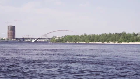 Wide view of the river and the bridge in the background. Fast flowing river Video stock 197063791