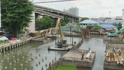 Wide view of river construction beside Bangkok's urban sprawl Stock Footage 345861379
