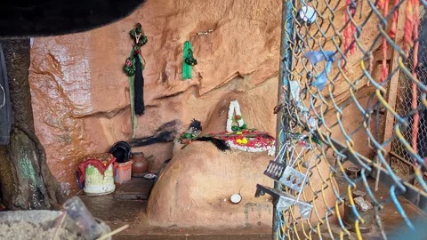 Wide view of sacred hindu deities and ritual offerings inside natural rock ca Stock-Footage 346817148