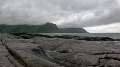 Wide view of smooth granite rocks and misty ocean mountains in Senja Norway 스톡 동영상 342059424