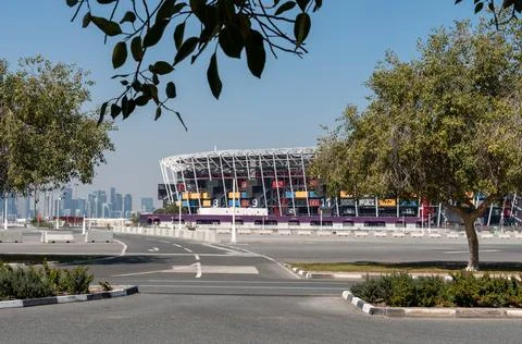 Wide view of Stadium 974 framed by trees and West Bay skyline in the background. Stock Photos