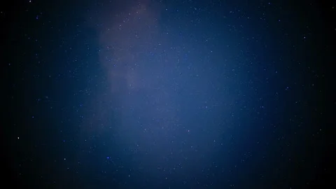 Wide view of a starry night sky with an amber glow near the horizon Stock Footage 344827244