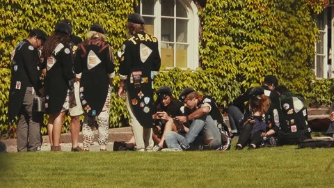 Wide view of students in black jackets covered with patches and wearing Stock Footage 98475104