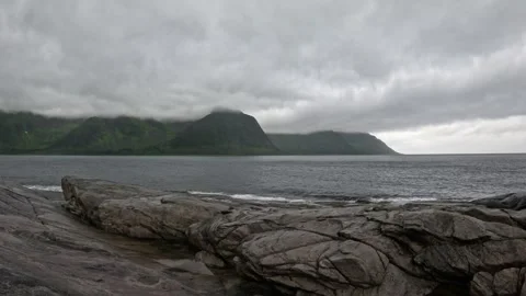 Wide view of textured granite coast and misty ocean mountains in Senja Norway 動画素材 342059418
