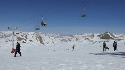 Wide view of Tochal ski slope with snowboarders and chairlift in Alborz Video stock 321032268