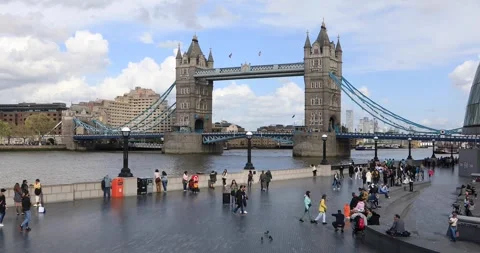 Wide view of Tower Bridge and busy riverside promenade in London Stock Footage 321018023