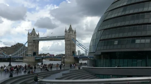 Wide view of Tower Bridge and busy riverside promenade in London Stock Footage 321033087