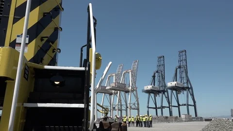 Wide view from the train of a group of men in hard hats at a San Francisco port. Stock Footage 123392487